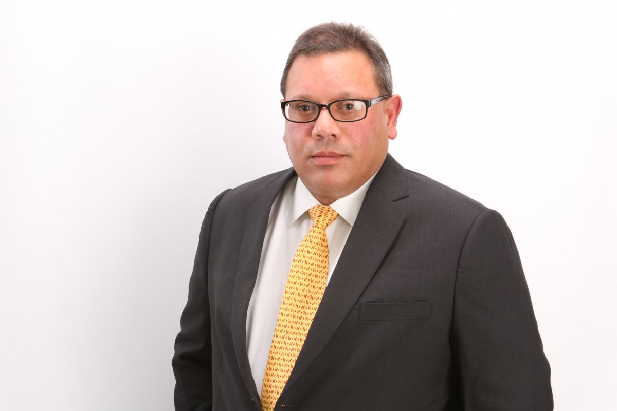 A photo of Jag Singh wearing a gray suit and a yellow tie